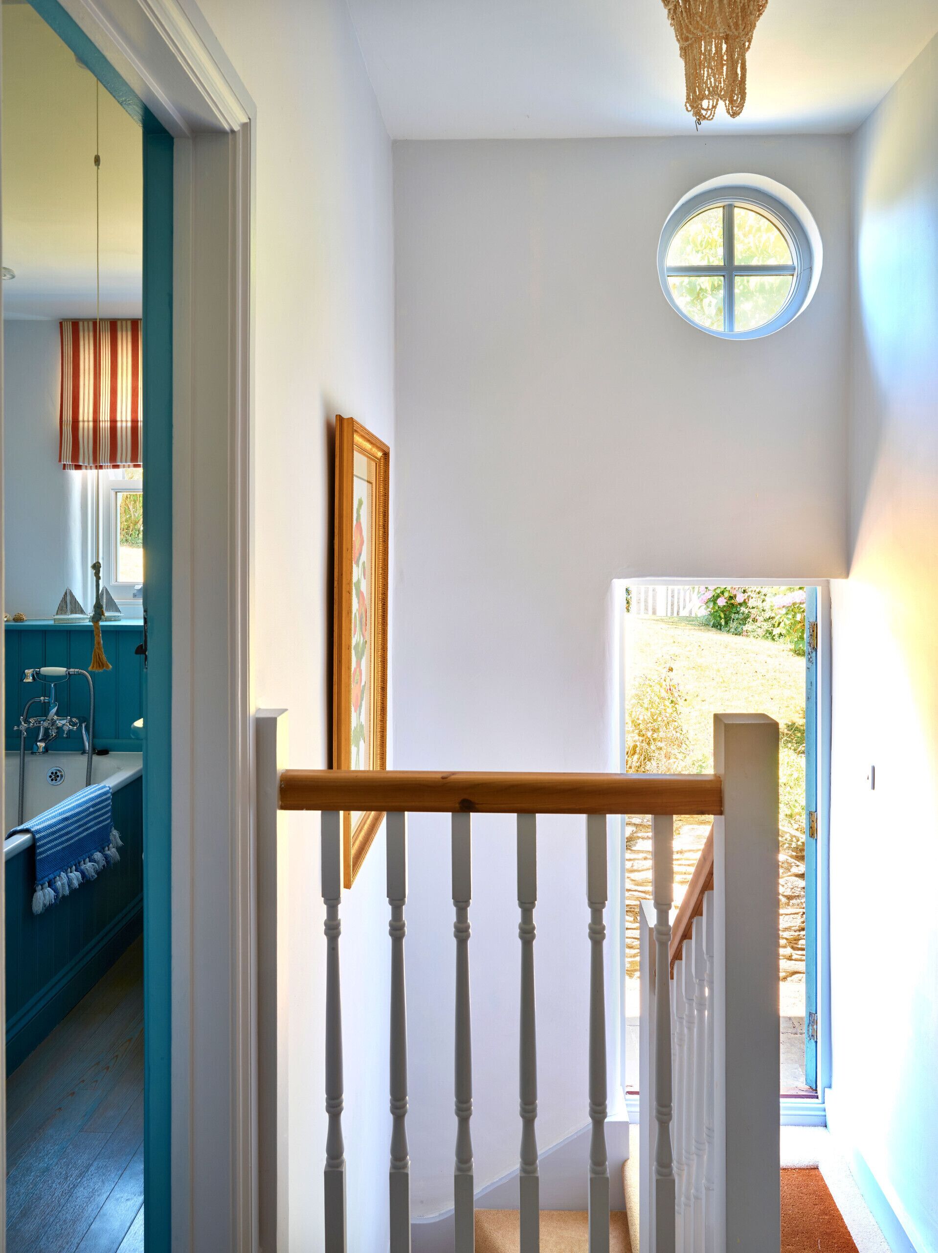 Una escalera con barandilla de madera que lleva a una plataforma con vistas a un jardín.