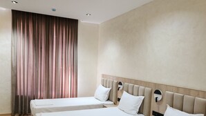 A hotel room with three single beds, a wooden headboard, and a large window with curtains. - HORIZON HOTEL (Tashkent)