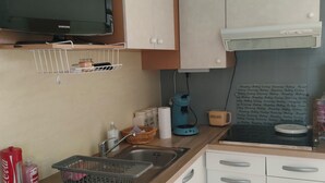Een kleine keuken met een magnetron, gootsteen en koffiezetapparaat.