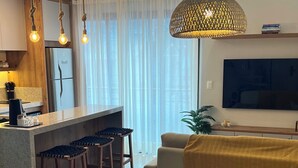 Una cocina moderna con una isla central, taburetes de bar e iluminación colgante.