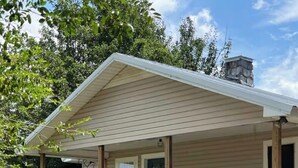 A single-story house with a covered porch, a front door, and a small staircase leading to the entrance. - Adorable 2-bedroom Farmhouse in beautiful Lake Guntersville (Guntersville)