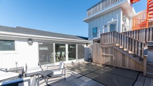 Une terrasse avec des sièges et un escalier menant à un deuxième étage.