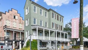 A two-story building with a balcony and a porch, featuring a sign that reads "Welcome to PARADISO MARKET."
