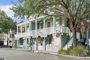 A two-story building with a balcony and a sign with a letter 'M'. - 5 BR @ Paradiso Pool Club (North Charleston)