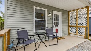 A porch with two chairs and a table, a wooden fence, and a house number 5736D. - Merlot Cottage - GOTL Strip - Lover's Retreat (Geneva)