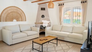 Una sala de estar con dos sofás, una mesa de centro de madera, un televisor y una chimenea de piedra.