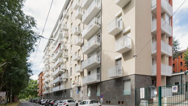 A multi-story residential building with balconies, a parking area, and a gated entrance. - GuestHost - Cozy 55 sqm apartment, perfect for 3 people, located on the second floor of a building with an elevator (NOT accessible to disabled guests).The property is located in the Corvetto neighborhood, in a quiet residential area just steps from Vett (Milan)