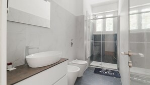 A modern bathroom with a freestanding bathtub, a toilet, and a glass shower enclosure. - GuestHost - Cozy 55 sqm apartment, perfect for 3 people, located on the second floor of a building with an elevator (NOT accessible to disabled guests).The property is located in the Corvetto neighborhood, in a quiet residential area just steps from Vett (Milan)