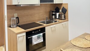 A compact kitchen with a microwave, coffee maker, and oven.