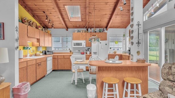 Een moderne keuken met houten kasten, een centraal eiland en een eethoek met barkrukken.