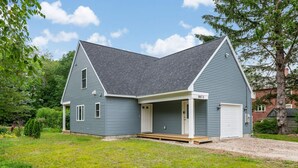 A two-story house with a covered porch and a garage.