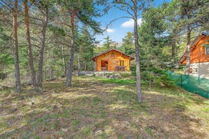 A cabin surrounded by tall pine trees, with a clear sky above. - Chalet 'Les Chalets' with Mountain View, Shared Terrace and Private Garden (Méolans-Revel)