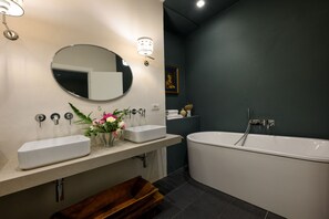 A modern bathroom with a freestanding bathtub, a double sink vanity, and a large mirror. - Duomo Luxury Apartment with plunge pool (Firenze)