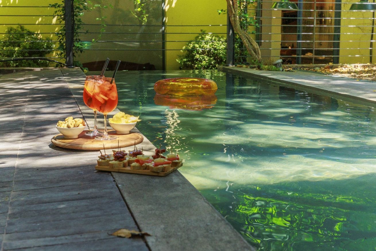 Un cadre agréable au bord de la piscine, avec des boissons, des en-cas et un objet flottant.