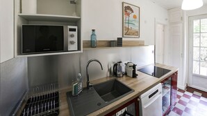 Eine Küche mit Mikrowelle, Spüle und Kaffeemaschine.