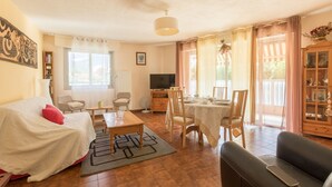 Un salon confortable avec un canapé, une table à manger et un téléviseur.