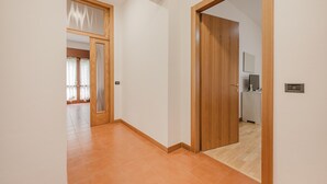 Ein Flur mit einer Holztür, die in einen Küchenbereich führt.
