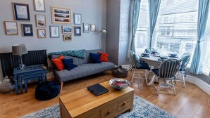 Uma sala de estar moderna com sofá, mesa de centro e área de jantar.