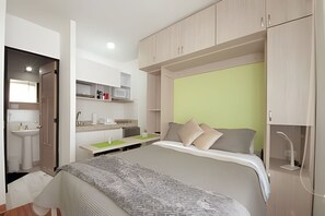 Ein modernes Schlafzimmer mit einem Bett, Nachttisch und einem Einbauschrank.
