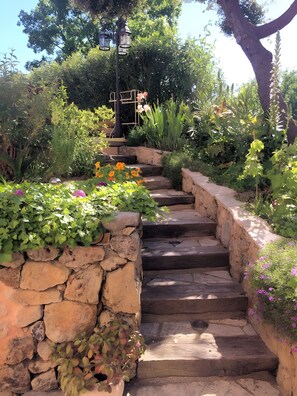 Una escalera de piedra rodeada de exuberante vegetación y flores.