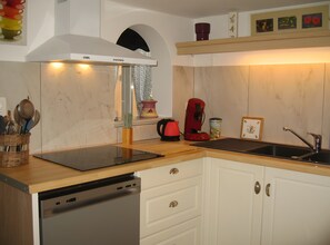 A kitchen with a dishwasher, a coffee maker, and a sink.