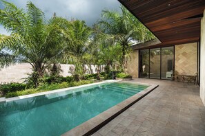 A modern outdoor pool area with a wooden pergola, surrounded by lush greenery and palm trees. - ONYX Park Resort Ubud (Ubud)