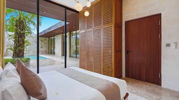 Un dormitorio moderno con una cama grande, un separador de madera y vista a una piscina.