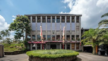 Un edificio moderno con un patio central, un acceso cubierto y una estatua.