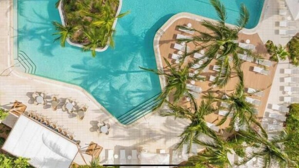 An aerial view of a swimming pool with a small island, surrounded by palm trees and lounge chairs. - SkyVilla Penthouse 3BD  3BA in Hotel 601 Miami (Miami)