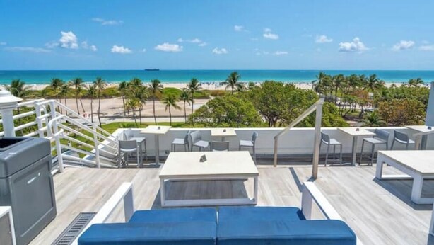 Terraço no telhado com vista para a praia, área de estar ao ar livre e piscina.