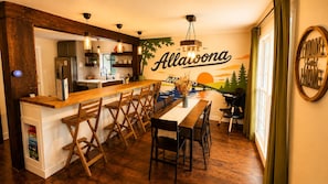 Uma cozinha com balcão de madeira, banquetas de bar e um mural com a palavra 'Alavona'.
