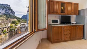 Une cuisine avec des meubles en bois, un four à micro-ondes et un téléviseur.
