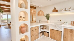 A modern bathroom with a marble sink, wooden cabinets, and a large mirror.