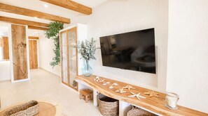 Un salon moderne avec une console en bois, un téléviseur à écran plat et un grand miroir.