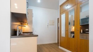 A modern kitchen with a built-in oven, a stainless steel sink, and wooden cabinets. - Modern Studio by the River with Wi-Fi and Air Conditioning (Seville)