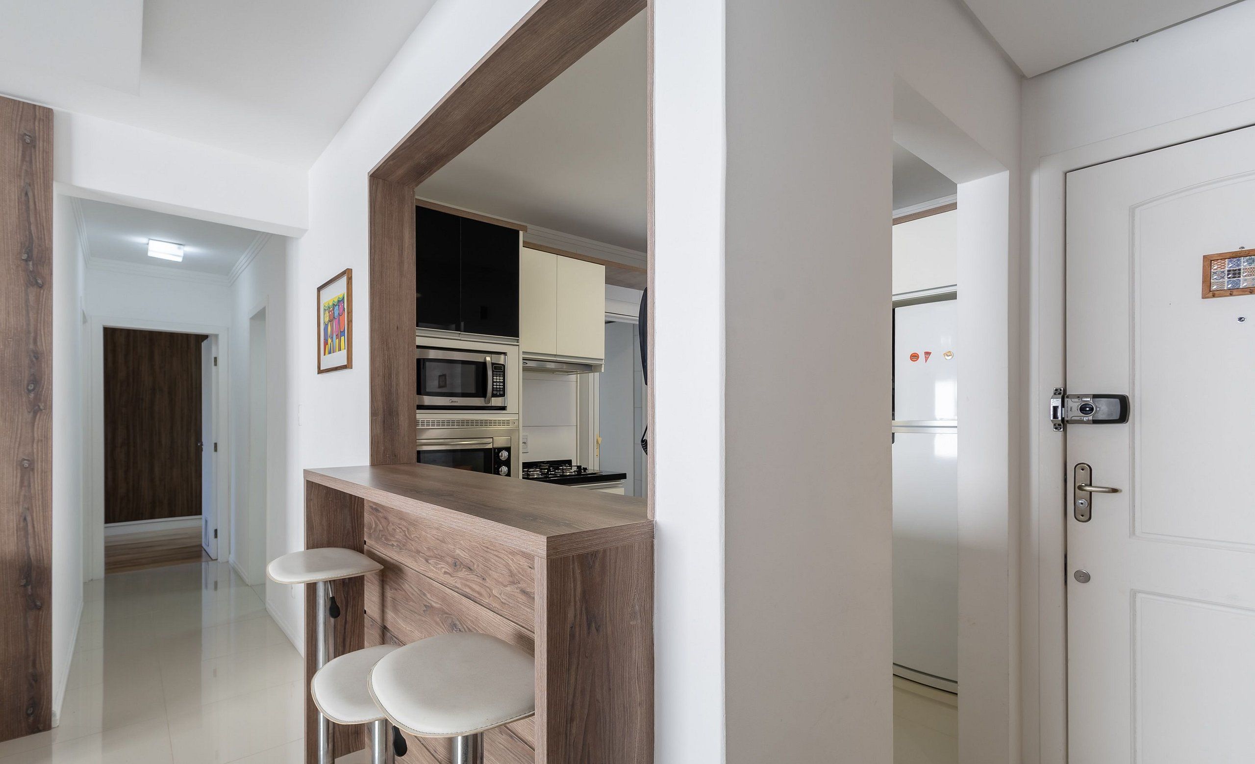 A modern kitchen with a wooden countertop and two bar stools.