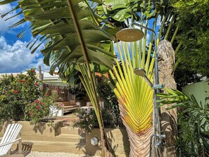 A hammock suspended between trees, a white chair, and a small table with a plant. - 2 apartments at Casa Uva Verde 2AP/2BR/5PER (Willemstad)