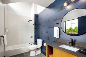 A modern bathroom with a bathtub, toilet, and sink.