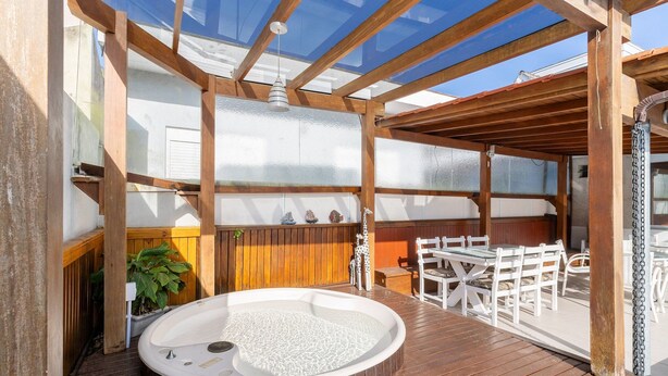 A wooden deck with a hot tub, white outdoor furniture, and a pergola with a glass ceiling. - Duplex W/pool 800m From the Beach in Jurere Dme025 (Florianópolis)