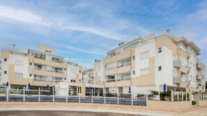 A modern apartment building with a swimming pool and outdoor seating area. - Apartment With Barbecue Near the sea Dov108 (Florianópolis)