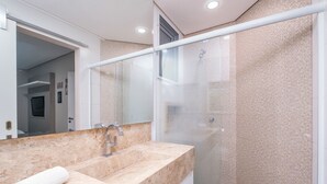 A modern bathroom with a marble sink, a glass shower enclosure, and a large mirror. - Apartment With Barbecue Near the sea Dov108 (Florianópolis)