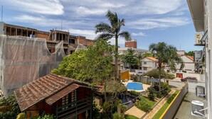 Zona residencial con una casa en construcción, una palmera y una piscina.