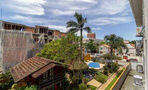 A residential area with a house under construction, a palm tree, and a swimming pool. - Apt w Barbecue 3 min by car From the Beach Dup0303 (Florianópolis)