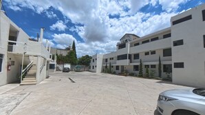 A spacious parking area with a white car, a staircase, and a building with a sign that reads "HOTEL". - PALACIO DE LOS ANGELES  (Puebla)