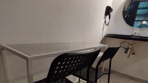 A small, private office with a desk and two chairs, a flat-screen TV mounted on the wall, and a round mirror above the mirror. - PALACIO DE LOS ANGELES  (Puebla)