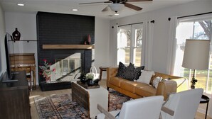 A living room with a fireplace, a sofa, a coffee table, and a television. - Casa del Toro (North Newton)
