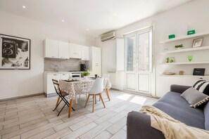 A modern apartment with a dining area, kitchen, and living space.