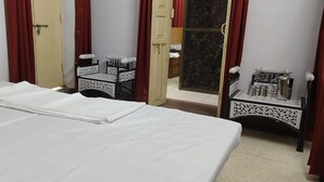 Une chambre d’hôtel avec un lit bien fait, une petite table avec une lampe et un miroir.