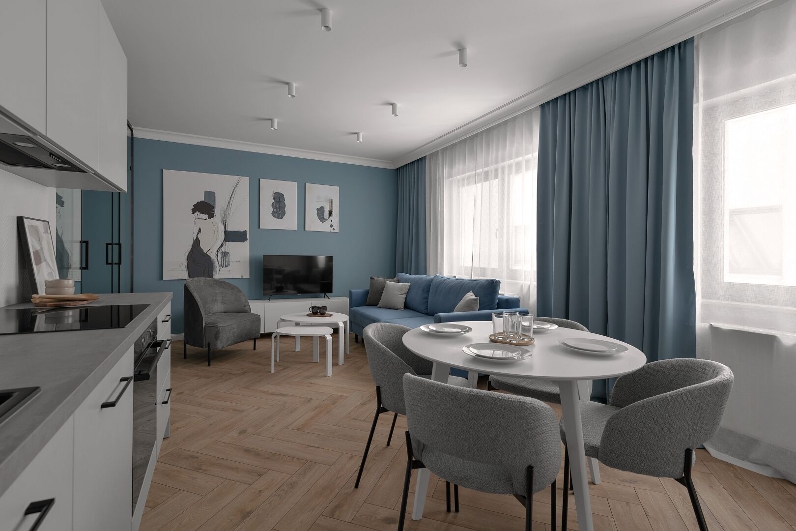 Una sala moderna con comedor, cocina y televisión.