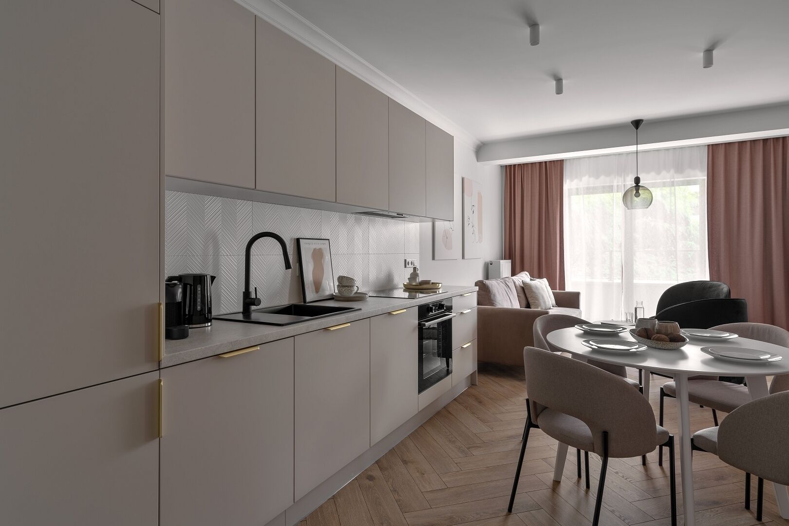 Una cocina moderna con horno empotrado y comedor con mesa redonda y sillas.